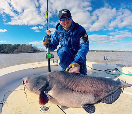 Zakk Royce, with a 100-pound catfish he recently caught. Photo Source ncwildlife.org.